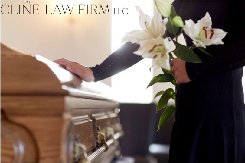 A women holding flowers with a hand on a casket